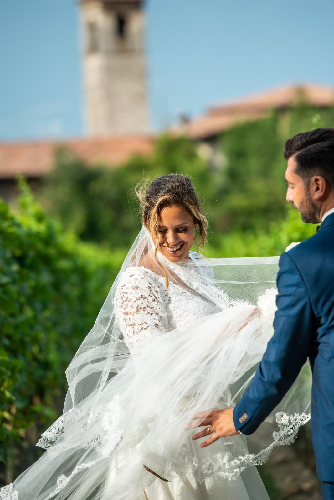 Sposa Anna tra i filari Franciacorta velo vento