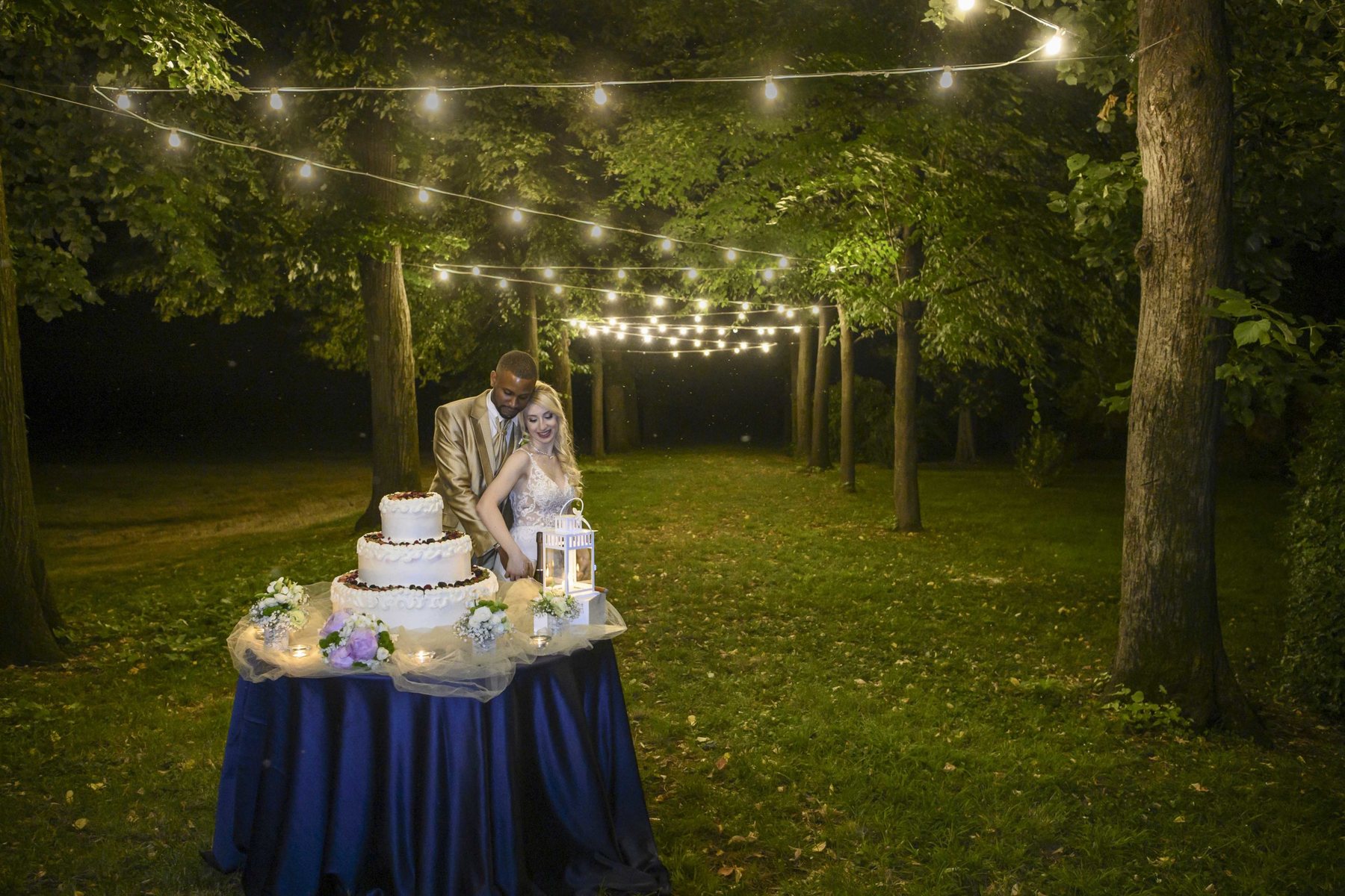 Taglio della torta nuziale notturno luci parco Villa Scheibler Rho